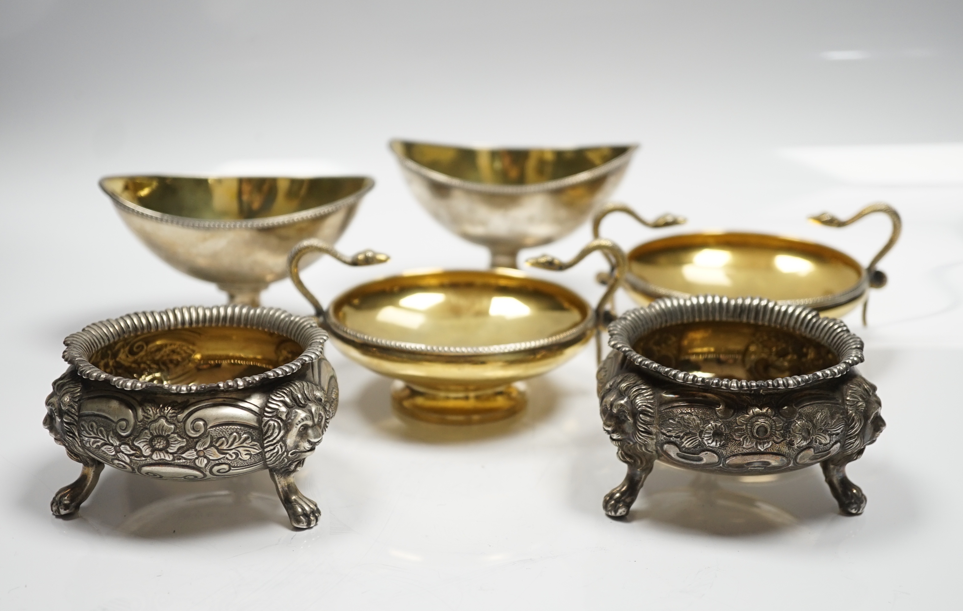 A pair of George V silver gilt shallow pedestal salts, with twin serpent handles, William Hutton & Sons, Ltd, Sheffield, 1928, width 11.8cm over handles, together with two matched pairs of Georgian silver salts, 20.3oz.